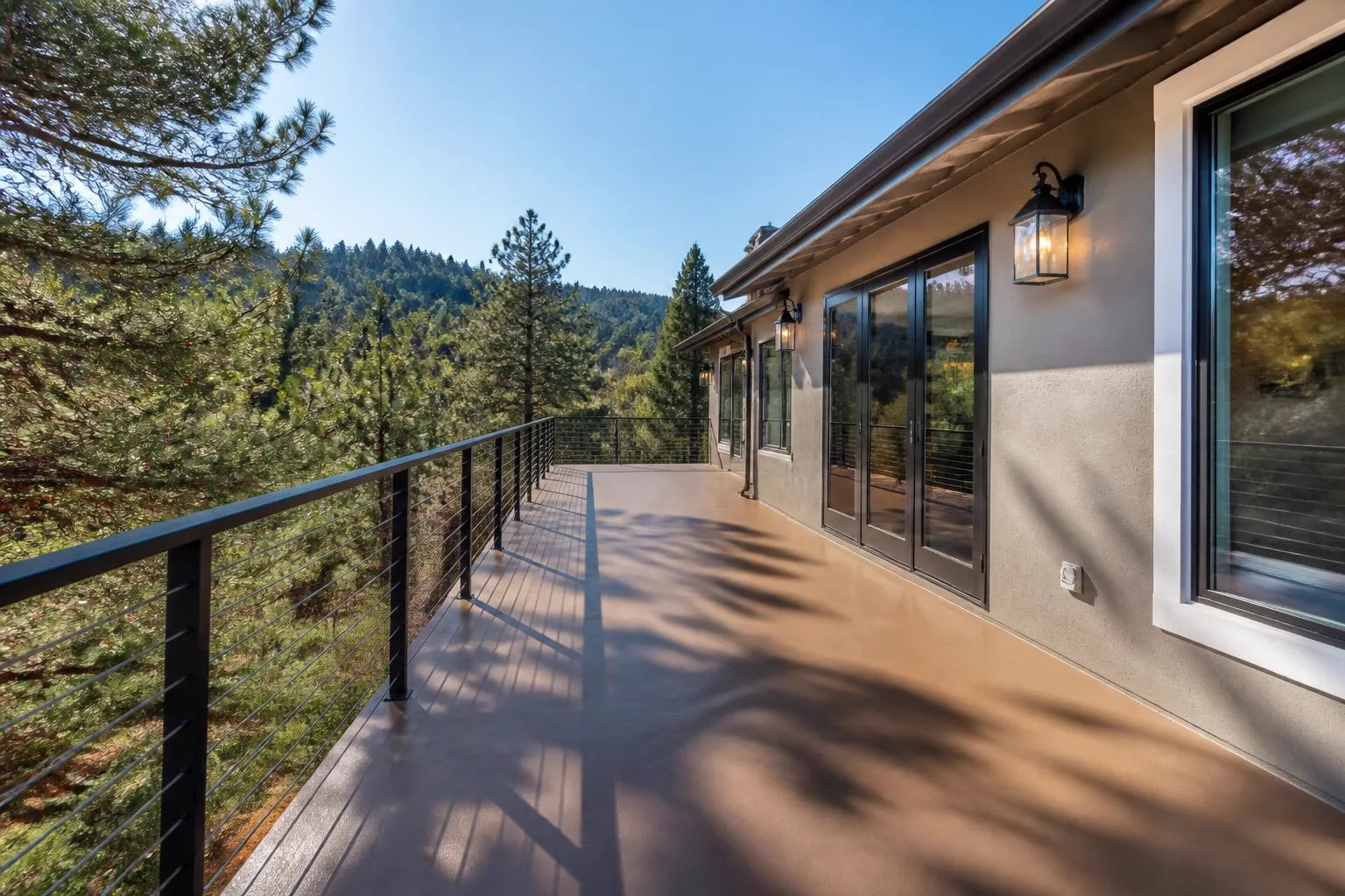 Finished elevated deck with smooth tan fiberglass reinforced elastomeric waterproof coating and new metal railing on a foothill home near Auburn California